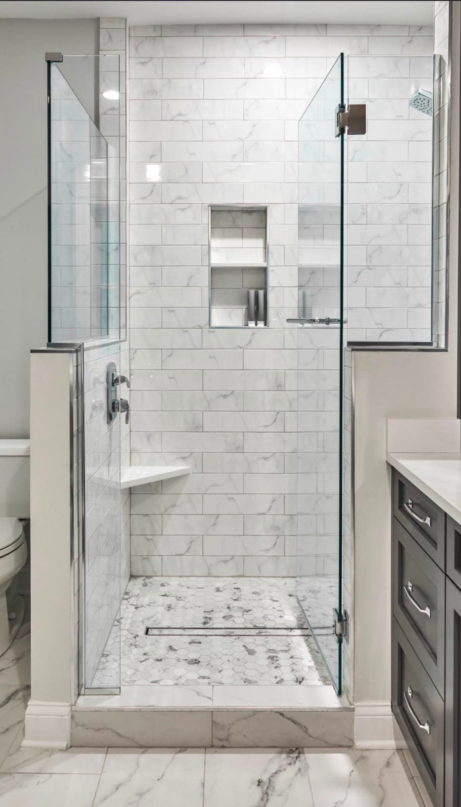 Walk-in shower with marble subway tile, chrome hardware, and frameless glass installed by Costa Bathroom Remodel in Ruskin, Florida